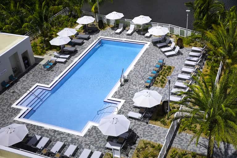 Aerial view of rectangular pool with loungers and white umbrellas