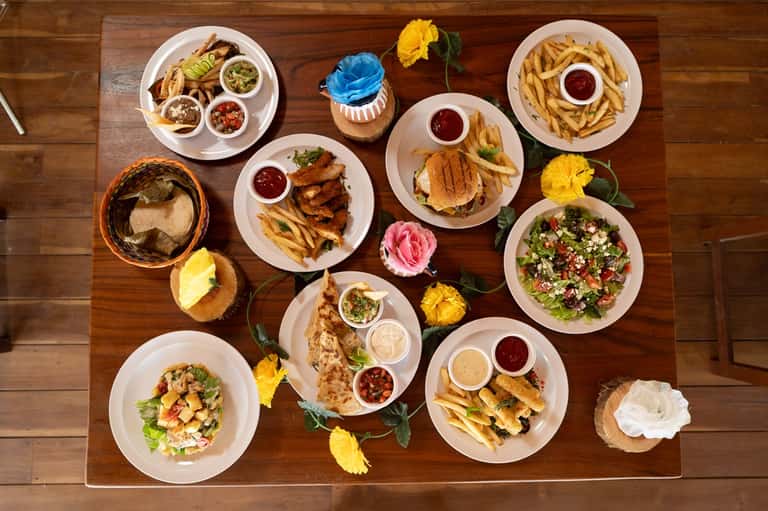 Overhead view of various appetizers and entrees on wooden table