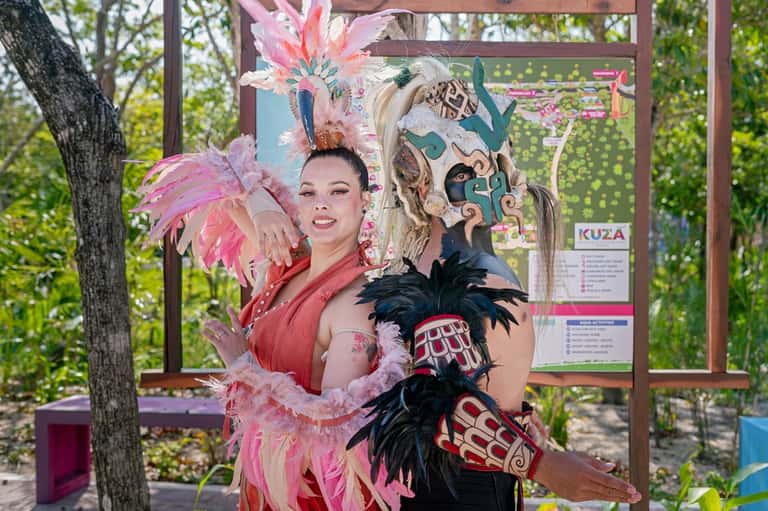 Entertainment performers in elaborate pink and black feathered costumes outdoors at resort