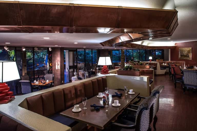 Modern hotel lounge with burgundy seating, fireplace, and large windows