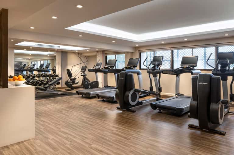 Modern fitness center with cardio equipment, treadmills, and floor-to-ceiling windows