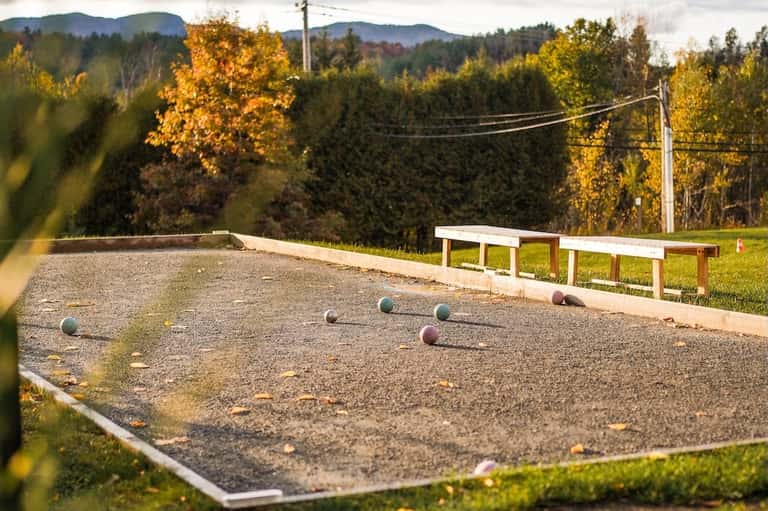 Bocce ball court in rural setting with autumn foliage and bench seating