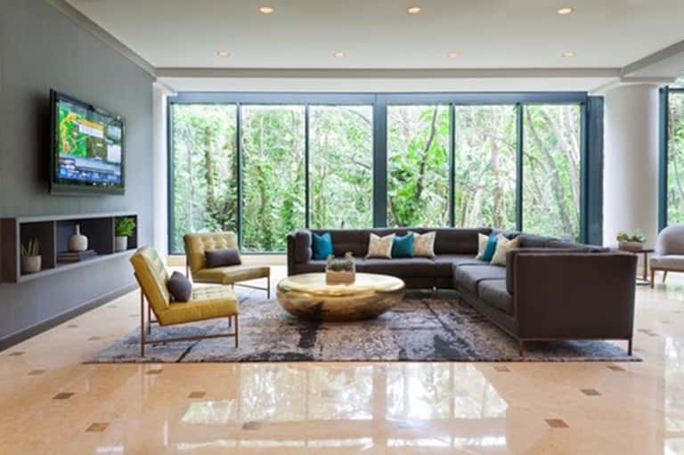 Modern lobby lounge with sectional seating, floor-to-ceiling windows, and forest view