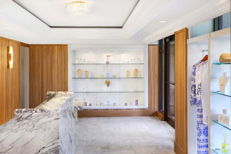 Upscale retail boutique with marble counter, wood accents, and glass display cases