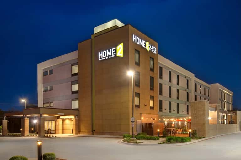 Home2 Suites hotel exterior at dusk with illuminated brick facade and modern architecture