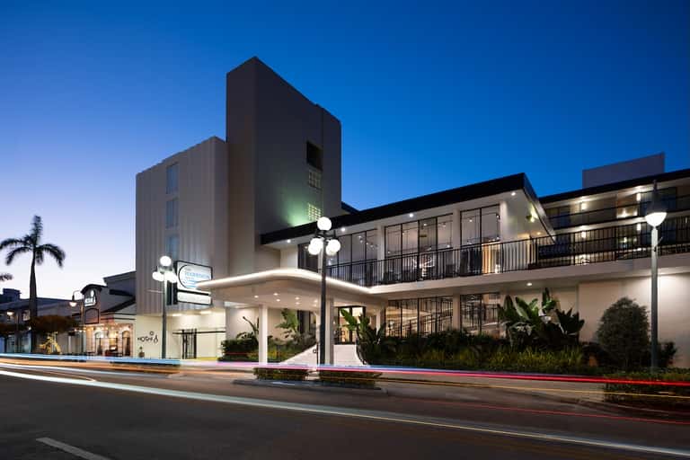 Contemporary hotel exterior at dusk with modern architecture and illuminated entrance