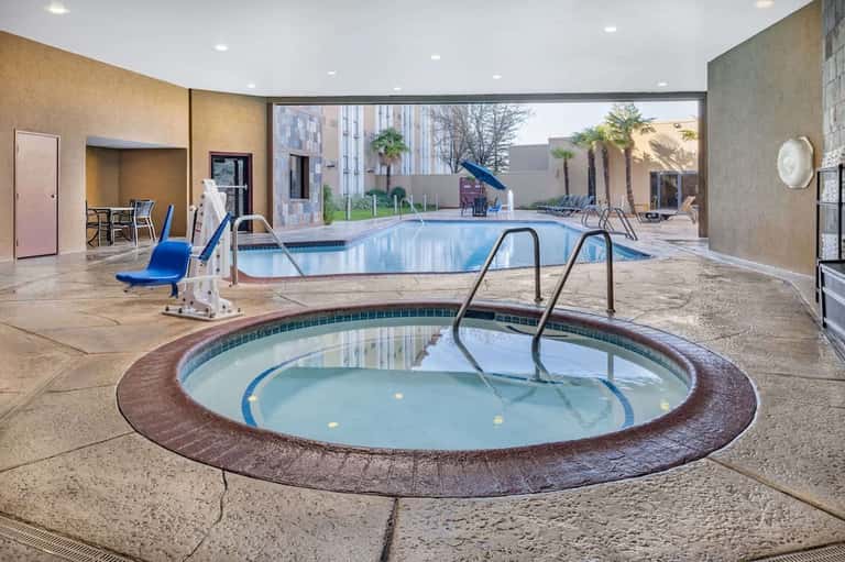 Indoor aquatic center with hot tub, lap pool, spa facilities, and poolside lounge areas