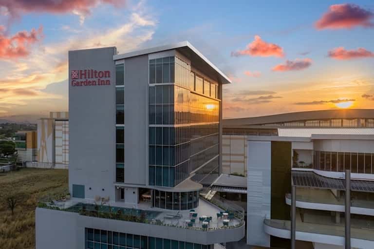 Modern Hilton Garden Inn building at sunset with contemporary architecture and landscaping
