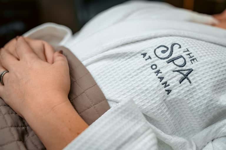 Close-up of spa robe with embroidered text held in guest's hands