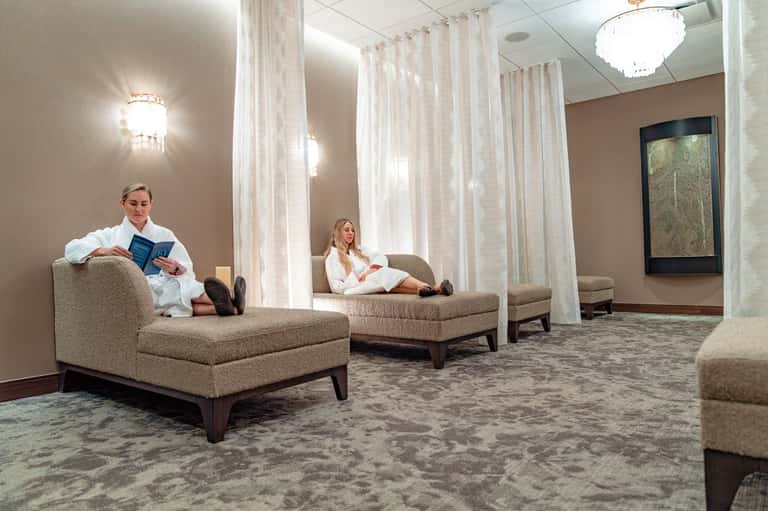 Spa relaxation area with comfortable lounge seating separated by sheer white curtains