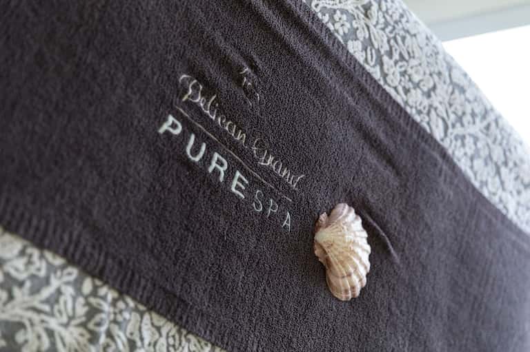 Close-up of hotel towel with seashell detail and pure spa branding