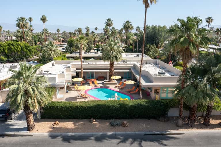 Colorful mid-century modern pool with geometric design, loungers, and desert landscape