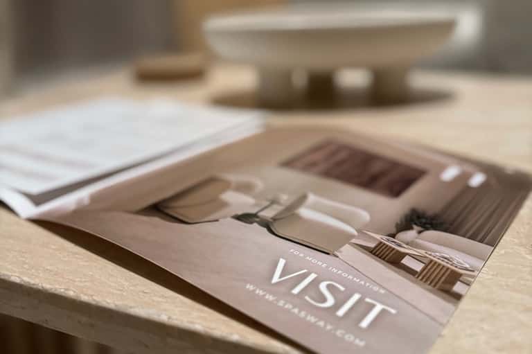 Close-up of spa brochure on marble surface with blurred spa imagery in background