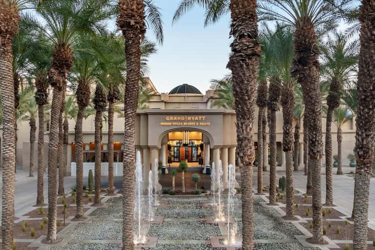 Grand Hyatt entrance courtyard with palm trees, fountains, classical architecture, and elegant facade