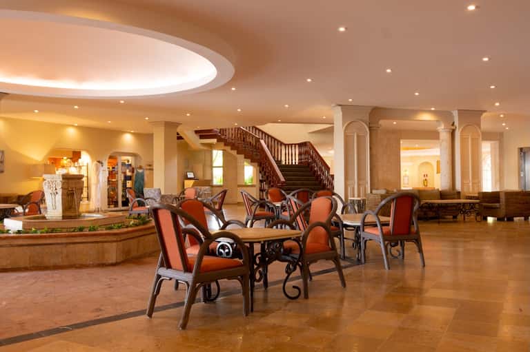 Elegant hotel lobby with curved staircase and comfortable seating area