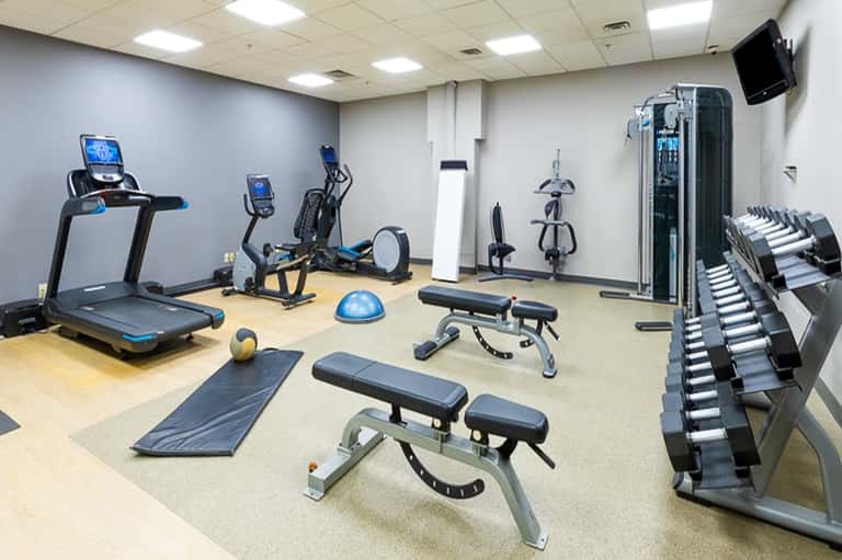 Well-equipped fitness center with treadmills, exercise bikes, dumbbells, and strength training equipment