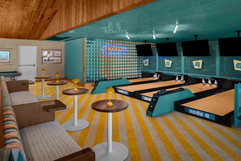 Retro-style bowling alley with turquoise walls, yellow striped flooring, and lounge seating area