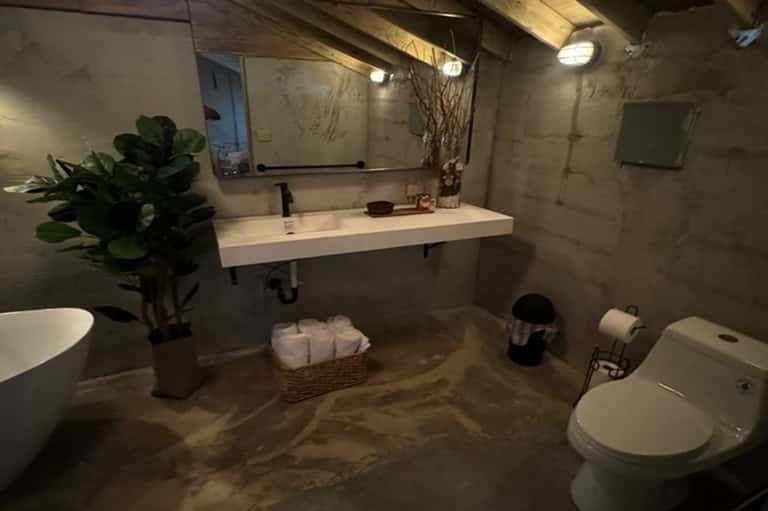 Modern bathroom with dual sinks, concrete flooring, mirrors, and minimalist design