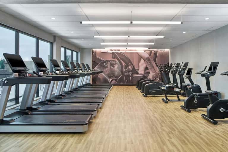 State-of-the-art fitness center with treadmills, stationary bikes, and floor-to-ceiling windows
