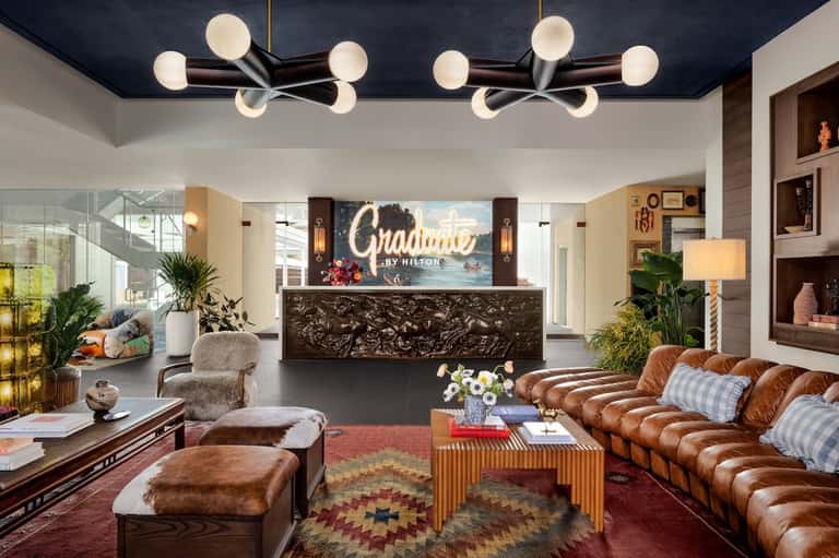 Hotel lobby with leather sofa, ornate desk, and modern pendant lighting
