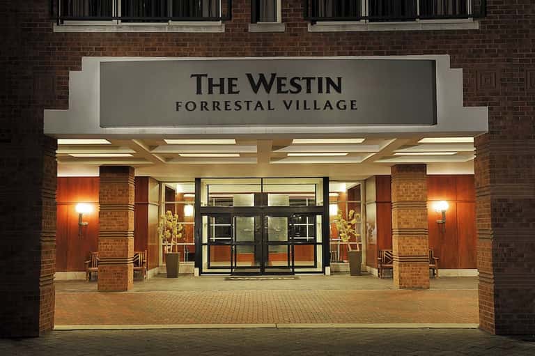 Evening entrance to The Westin Forrestal Village with brick facade and illuminated signage
