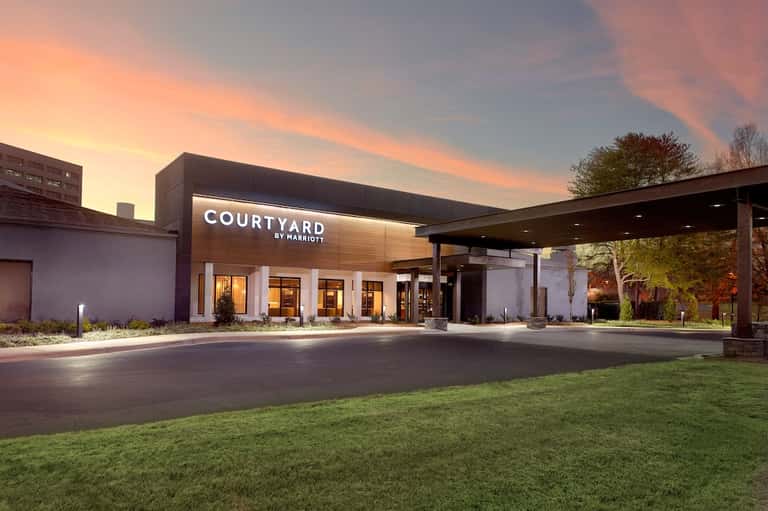 Courtyard by Marriott exterior at dusk with modern architecture and illuminated entrance.