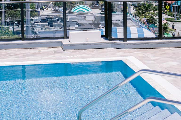 Indoor pool with glass windows, stepped entry, and bright natural lighting