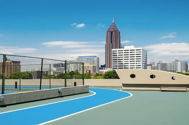 Rooftop basketball court with city skyline and tall building in background