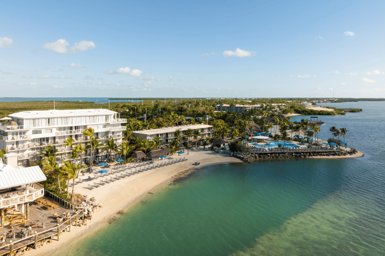 Beachfront resort with modern architecture, sandy beach, and turquoise water