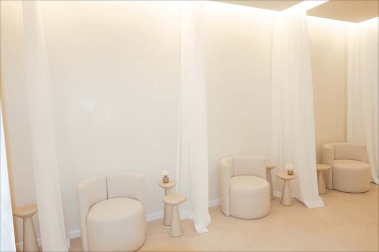 Spa relaxation area with cream-colored curved seating pods separated by curtains