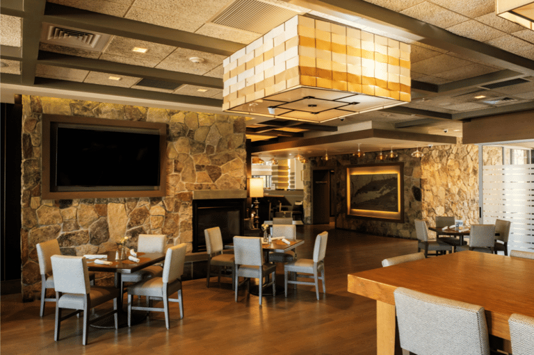 Resort dining area with stone walls, fireplace, and modern furnishings