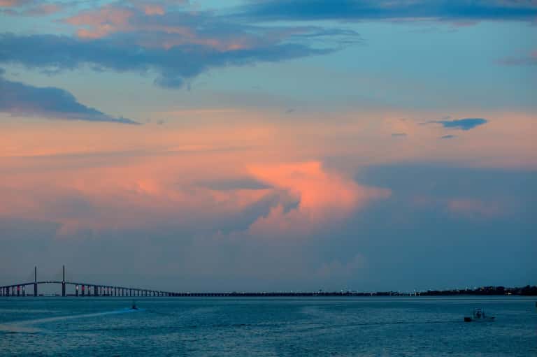 Sunset over bay with suspension bridge connecting mainland during golden hour