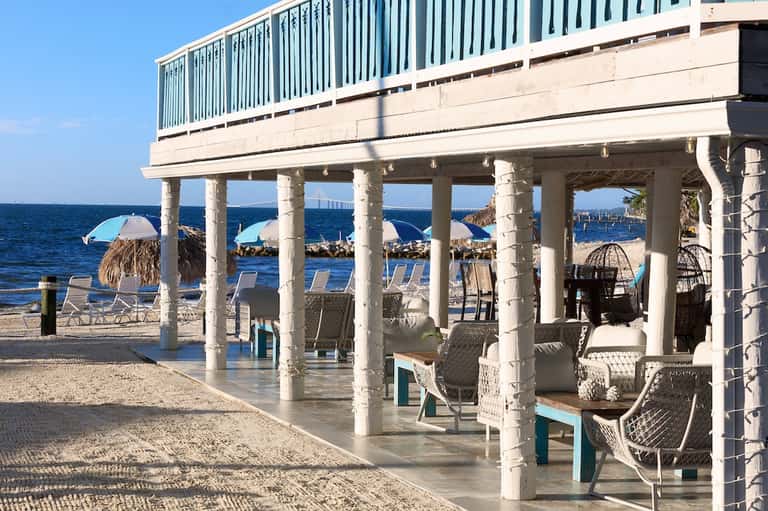 Beachfront pavilion with white columns, seating area, and ocean view