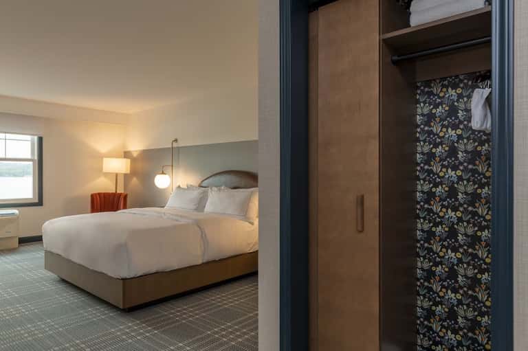 Bedroom with wood furnishings, patterned wardrobe, and warm ambient lighting