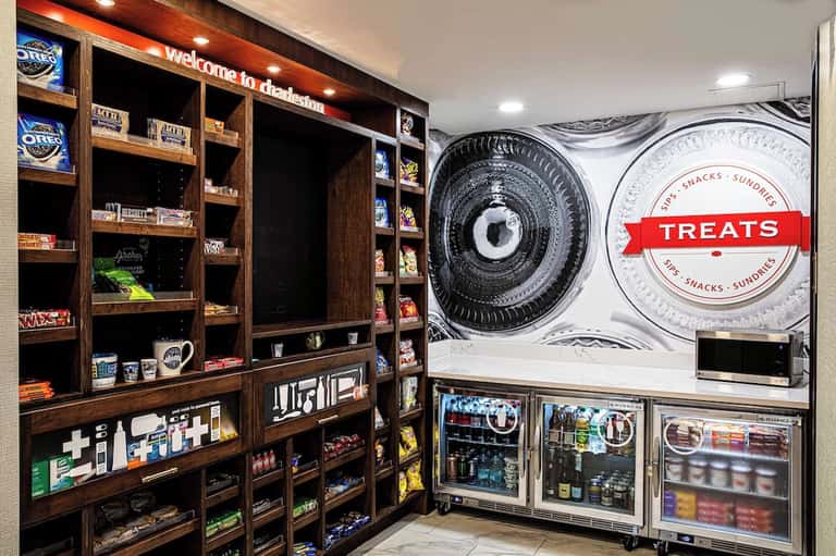 Hotel snacks and treats station with vending displays, shelving units, and branded signage