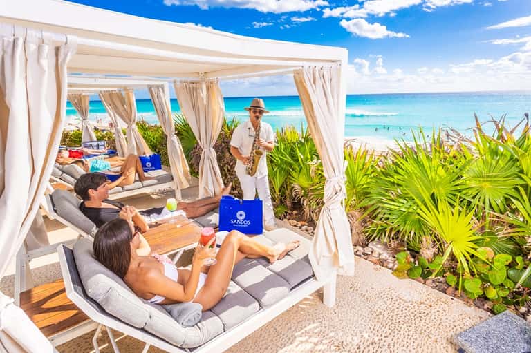 Beachfront cabanas with white curtains and ocean views on tropical beach