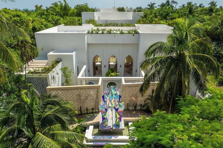 Contemporary white villa with arched doorways, rooftop garden, and colorful entrance art