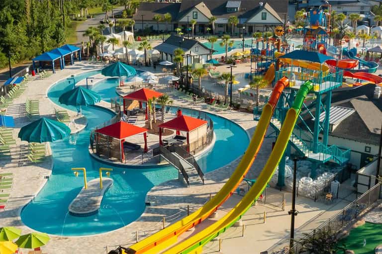 Aerial view of resort water park with turquoise pools, water slides, and play areas