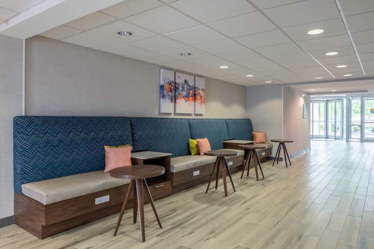 Modern hotel lounge with navy blue patterned seating, tables, and contemporary design