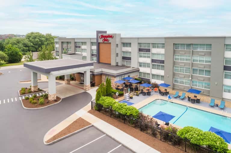 Hampton Inn exterior with porte-cochère, pool area, and landscaping