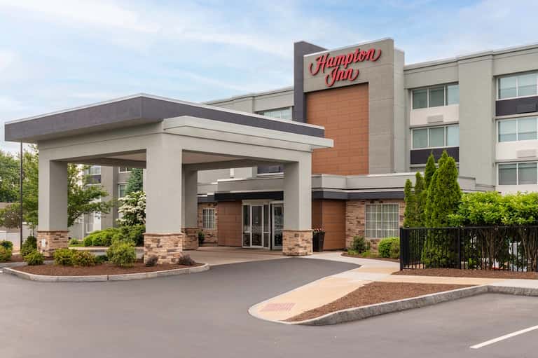 Hampton Inn hotel exterior with modern porte-cochere entrance and multi-story brick and stone façade