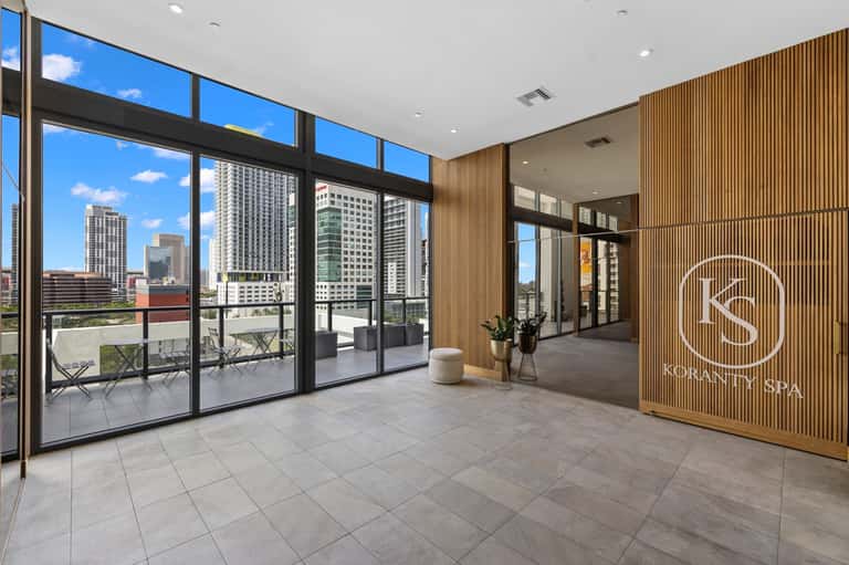 Urban spa entrance with city skyline views through floor-to-ceiling windows and modern wood paneling