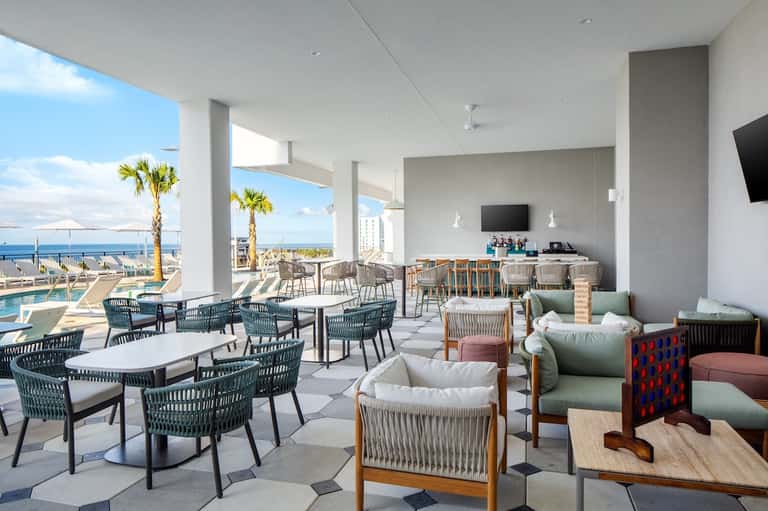 Modern oceanfront lounge with floor-to-ceiling windows and casual seating areas