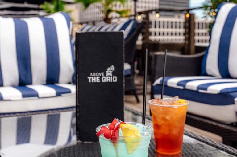 Rooftop bar with blue and white striped cushioned seating and colorful cocktails
