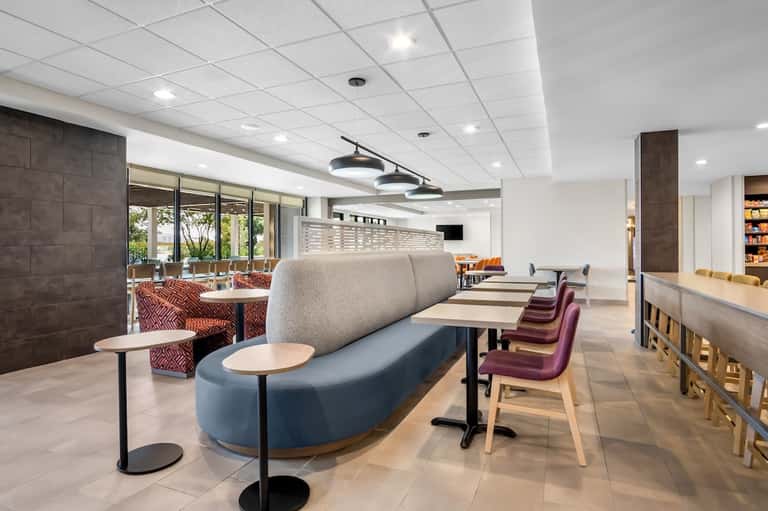 Contemporary hotel lounge with blue and gray curved seating and modern ceiling fixtures