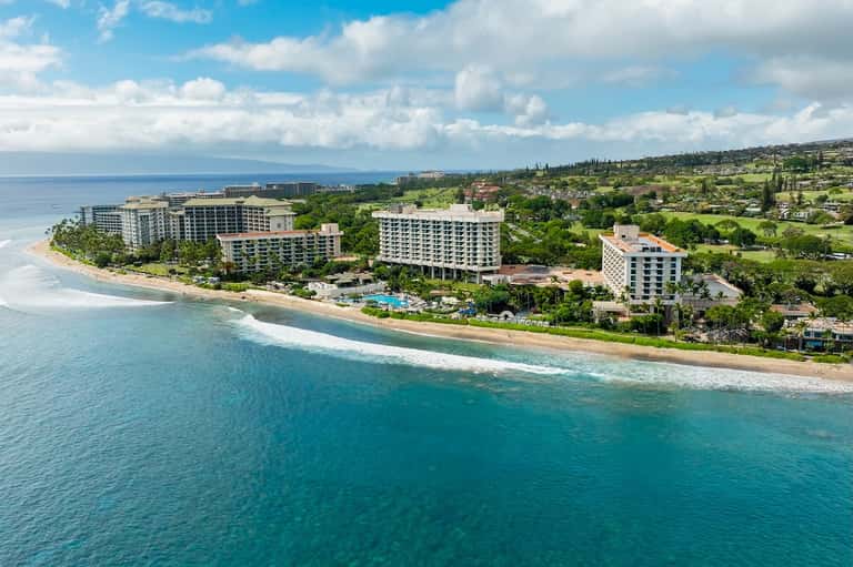 Aerial view of beachfront resort buildings on tropical coastline