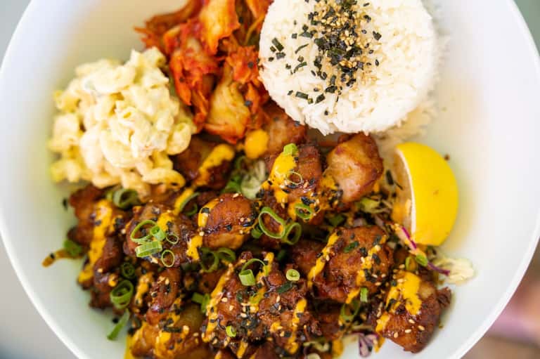 Gourmet plated dish with seared proteins, rice, and garnish on white plate