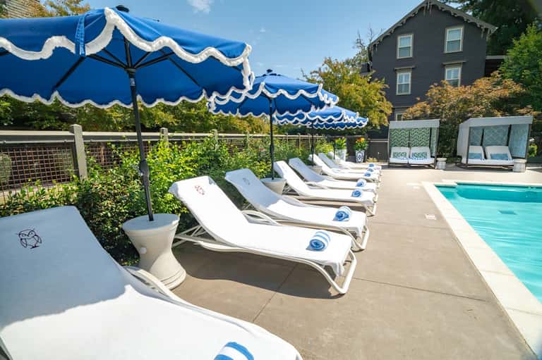 Poolside seating with blue and white striped umbrellas