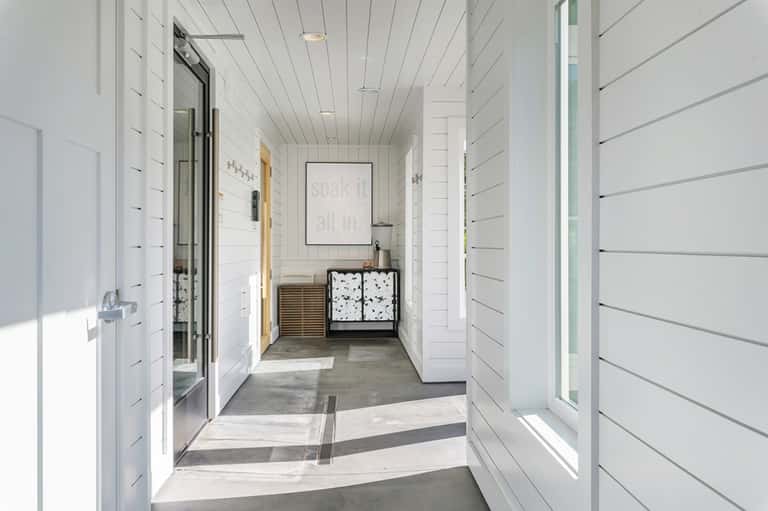 Modern white spa hallway with neutral tones and contemporary bathroom entrance
