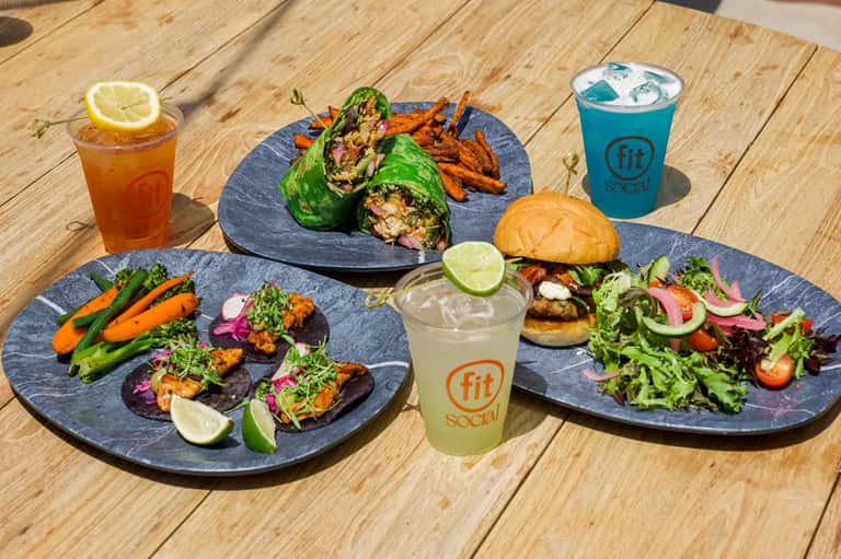 Healthy meal spread with wraps, appetizers, and branded beverages on wooden table